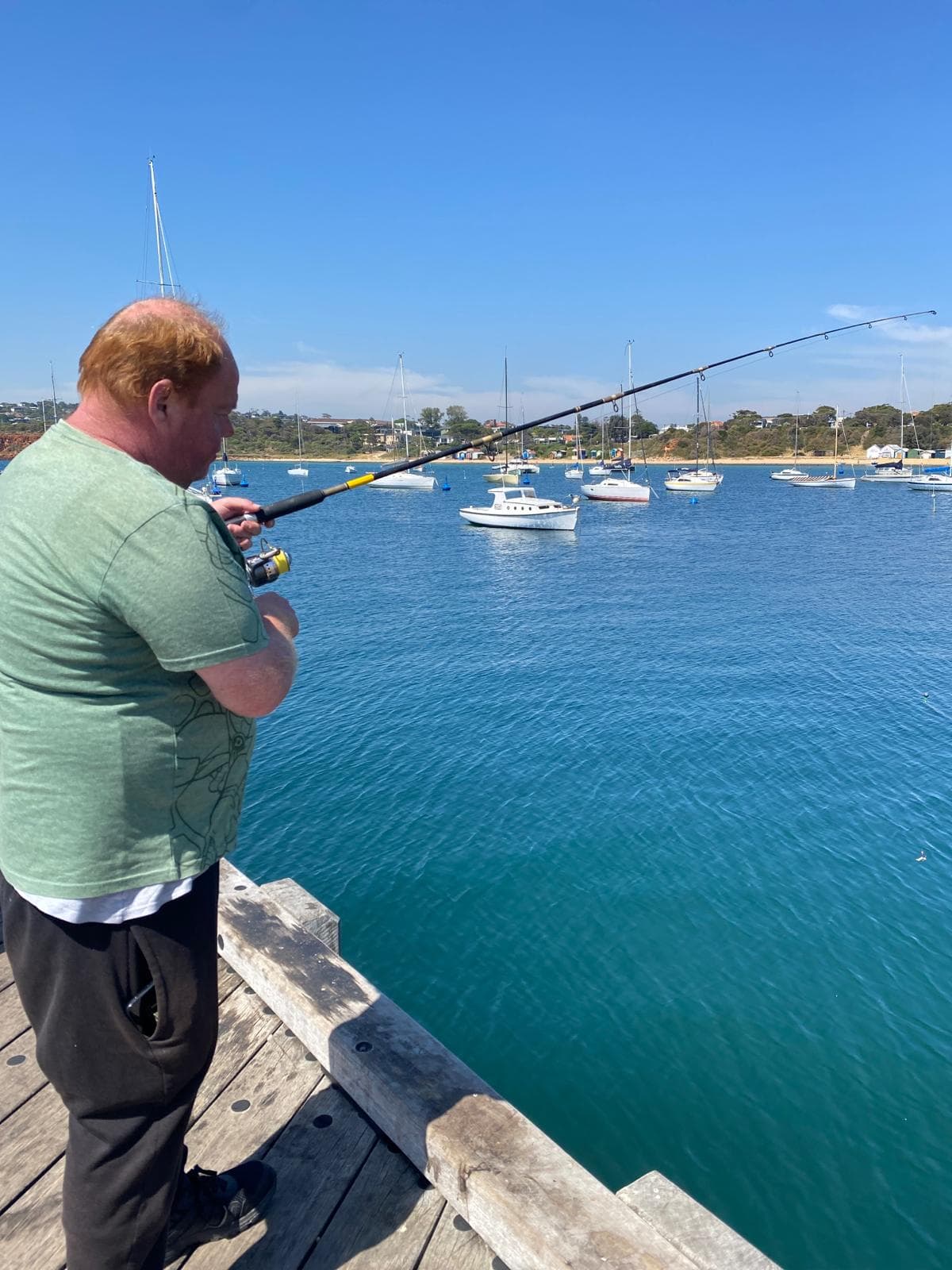 Support worker assisting a participant with fishing